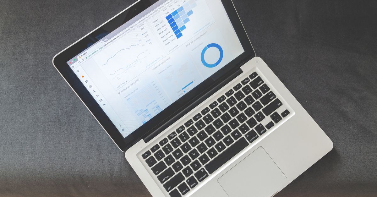 Overhead view of a laptop showing data visualizations and charts on its screen.