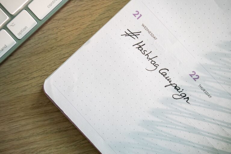 Social media automation planning with a content calendar and hashtag campaign on a desk