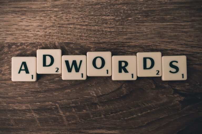Scrabble tiles spelling AdWords on a wooden surface representing Google Ads for small business