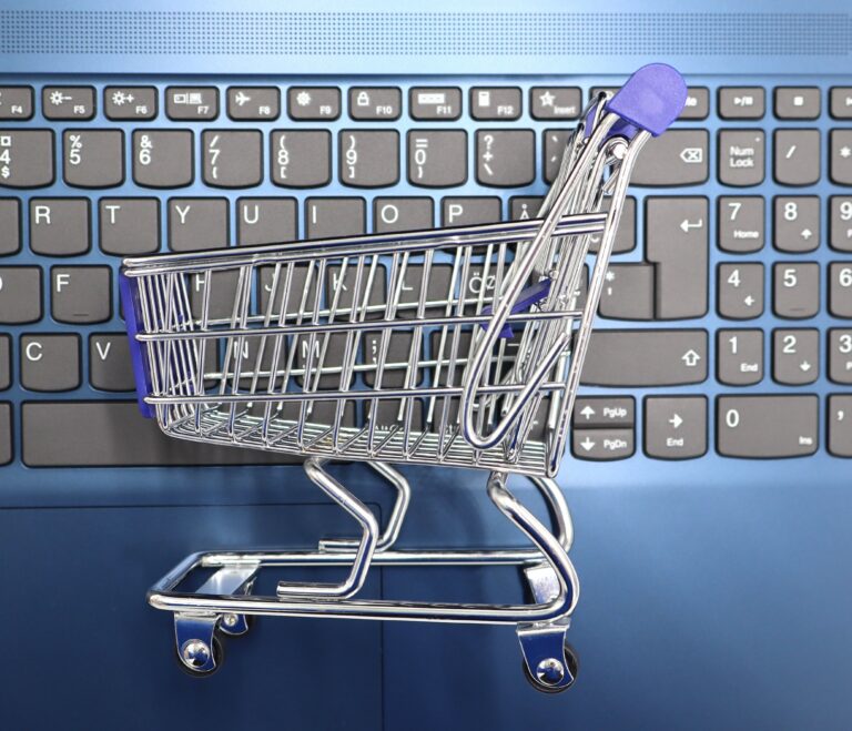 Miniature shopping cart on a laptop keyboard representing e-commerce and online store SEO
