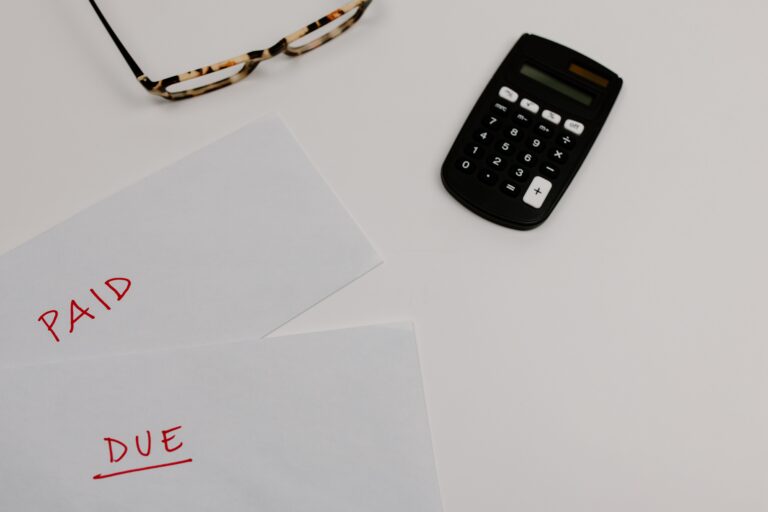 Financial papers labeled Paid and Due beside a calculator