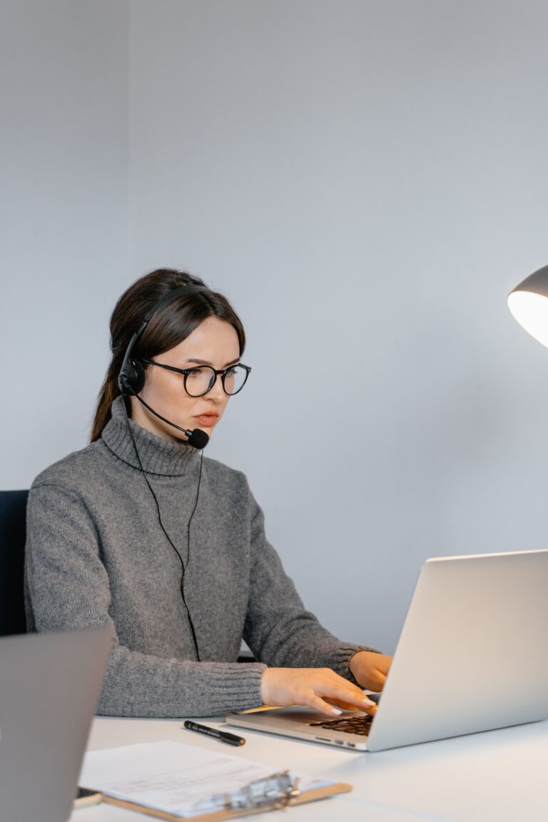Focused customer service representative with headset supporting customers on a laptop