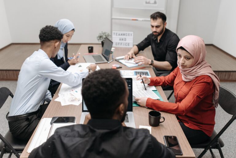 Too many meetings at work: a small team in a meeting at the office, meeting overload cost small business