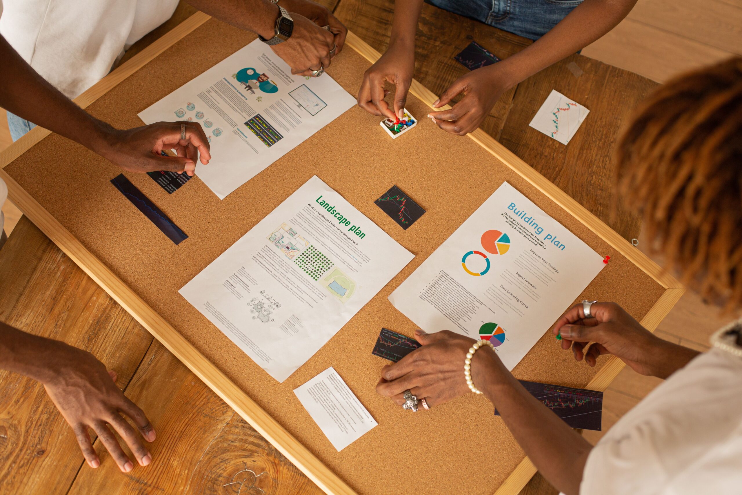 Diverse team collaborating on a project management board with charts and plans