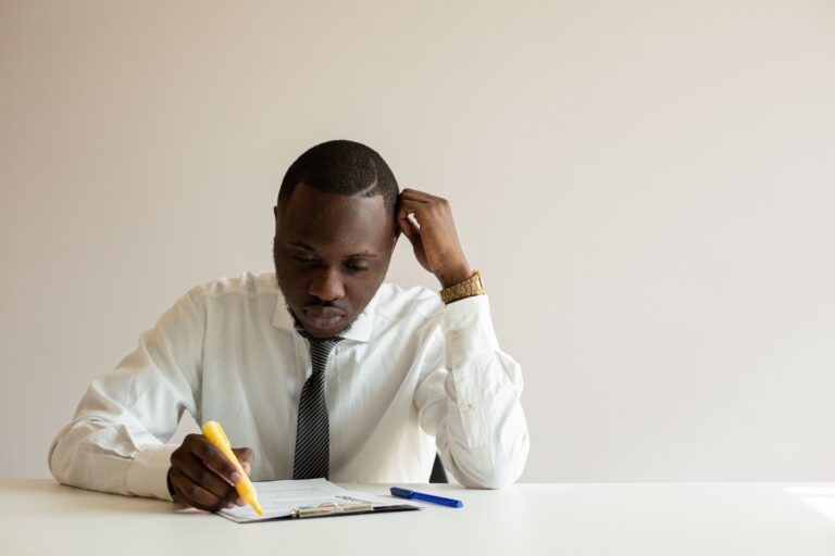 Small business owner deep in focused work, taking notes at a desk