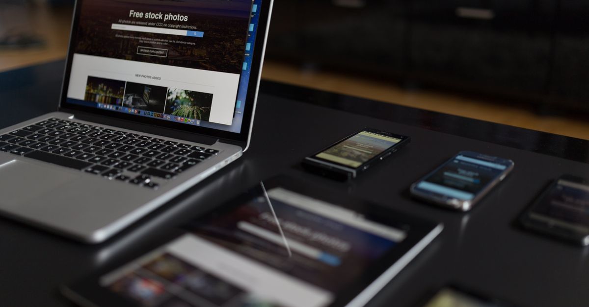 A contemporary workspace showcasing a laptop, tablet, and smartphones, ideal for tech and freelance use.
